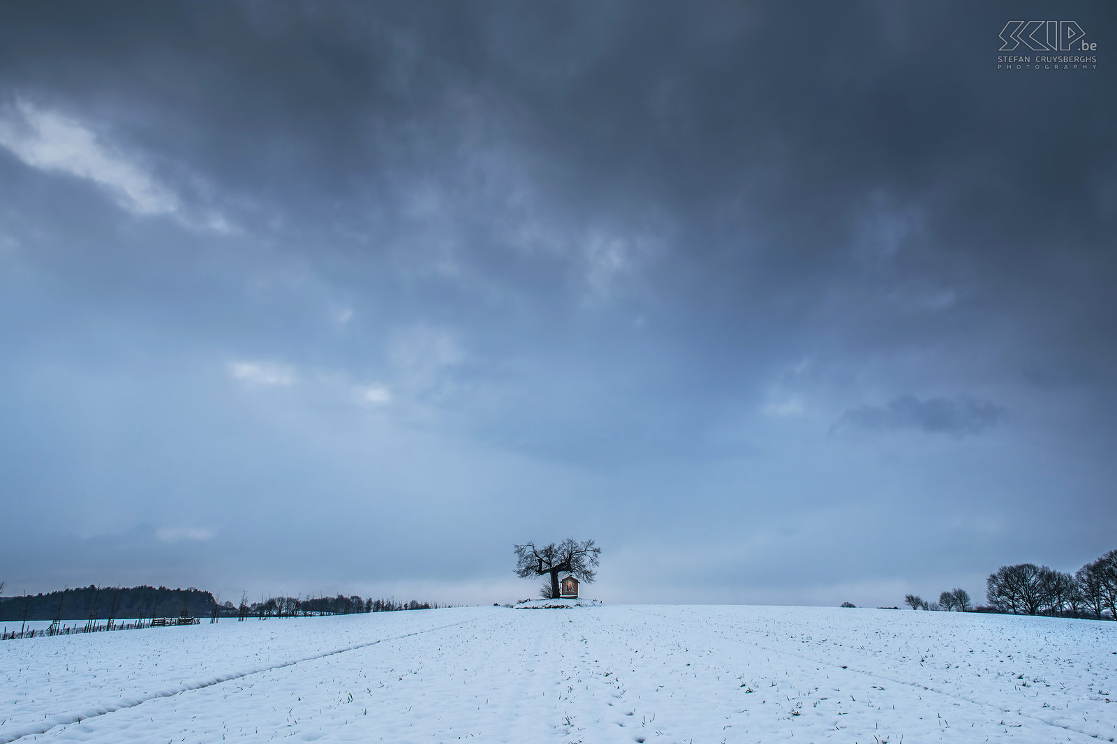 Winter in Sint-Pieters-Rode - Kapel bij dageraad De kleine kapel van Sint Jozef ligt in een veld in de buurt van het kasteel van Horst (Sint-Pieters-Rode) onder een oude linde boom. Deze foto werd gemaakt vlak voor zonsopgang. Stefan Cruysberghs